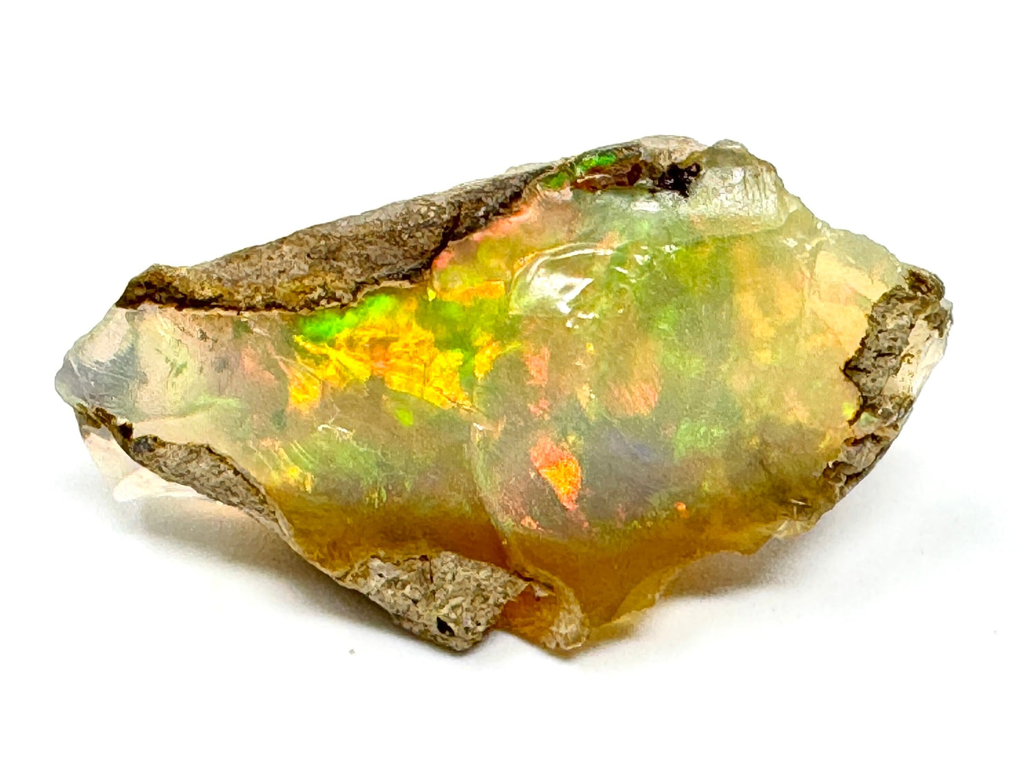 Raw Ethiopian Crystal Opal gemstone with opalescent play of colour in green, yellow, orange, and red flash. Precious opal also known as a Welo Opal Gem. 